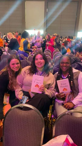 Ka'Mya Williams and fellow Aspiring Educators sit together during the plenary session, holding The Four Pivots as they engage in discussions on leadership, advocacy, and the future of public education.